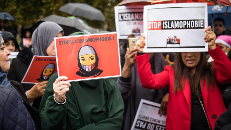 epa07953714 Veiled women hold posters reading 'Stop Islamophobia' as people and members of anti-racism associations gather to protest against Islamophobia at the 'Place de la Nation' in Paris, France, 27 October 2019. A debate about mothers wearing the Muslim headscarf in school outings has sparked across France since right-wing opposition parties' bill to prohibit mothers of students from wearing religious signs during school activities. EPA-EFE/CHRISTOPHE PETIT TESSON