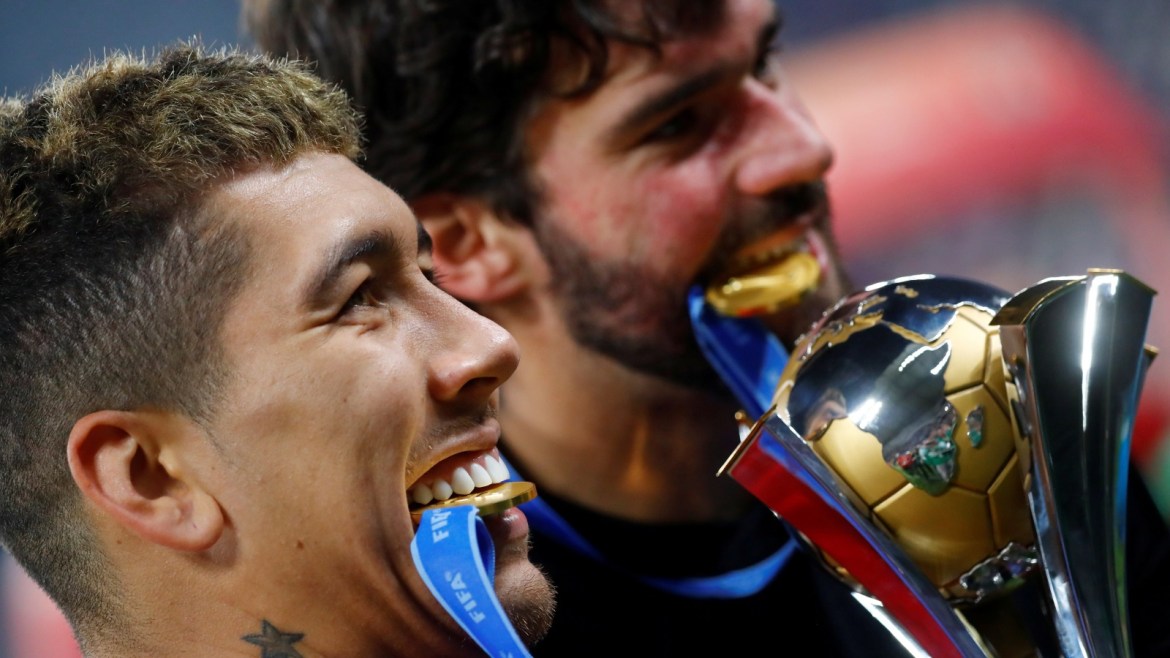Soccer Football - Club World Cup - Final - Liverpool v Flamengo - Khalifa International Stadium, Doha, Qatar - December 21, 2019  Liverpool's Roberto Firmino and Alisson pose with their medals and the trophy as they celebrate after winning the Club World Cup  REUTERS/Kai Pfaffenbach     TPX IMAGES OF THE DAY