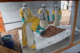 ATTENTION EDITORS - VISUALS COVERAGE OF SCENES OF INJURY OR DEATH Health workers dressed in protective suits prepare the body of Congolese woman Kahambu Tulirwaho for burial after she died of Ebola, at an Ebola treatment centre in Butembo, in the Democratic Republic of Congo, March 28, 2019. Picture taken March 28, 2019. REUTERS/Baz Ratner
