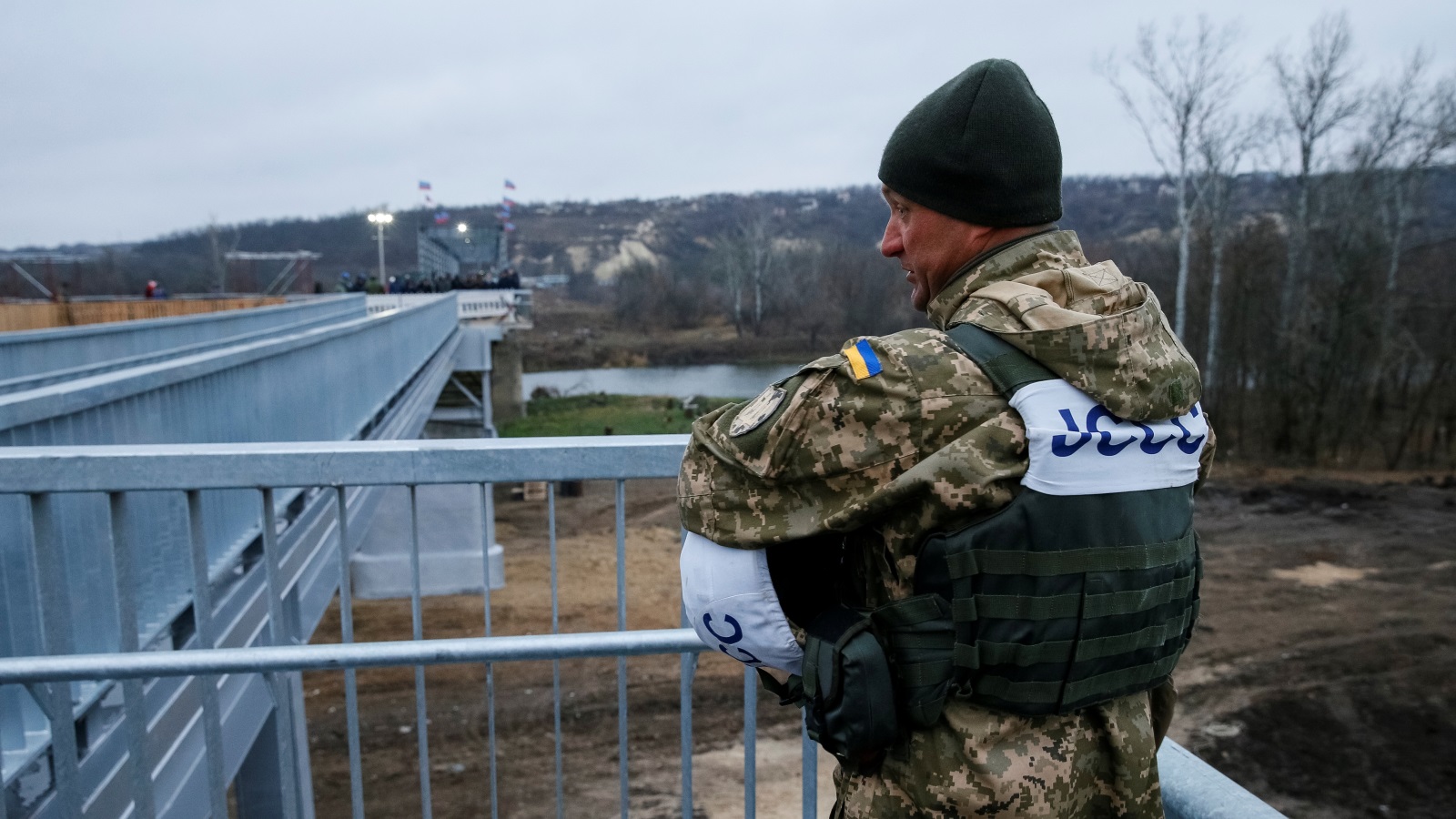 ‪جندي أوكراني يقف عند جسر أعيد بناؤه بعدما تهدم جراء الاشتباكات الدائرة بين القوات الأوكرانية والانفصاليين في شرق البلاد‬ (رويترز-أرشيف)