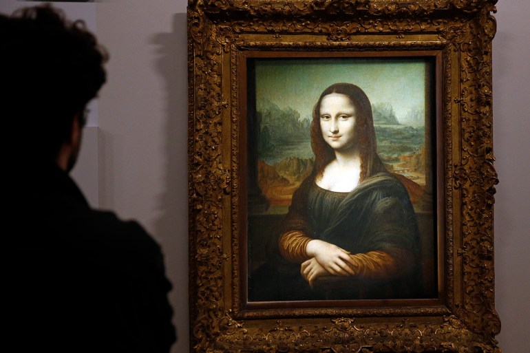 A visitor looks at a portrait of Lisa Del Giocondo by the Italian artist Leonardo da Vinci, a version of the Mona Lisa displayed during a press preview of the "La