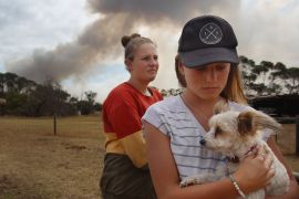 KANGAROO ISLAND, AUSTRALIA - JANUARY 11: Bonnie Morris and sister Raemi Morris look on as their family and CFS firefighters battle bushfires at the edge of their family farm on January 11, 2020 in Karatta, Australia. Currently 212,000 hectares of land has been burnt and over 100,000 sheep stock lost, along with countless wildlife and fauna due to the devastating bushfires which began burning on January 4th. The fires have claimed two lives and at least 56 homes with the town of Kingscote cut off as the Country Fire Service (CFS) continues to battle a number of out-of-control blazes. Roads out of Kingscote, on the island's north-east, are closed due to a watch and act warning. (Photo by Lisa Maree Williams/Getty Images)