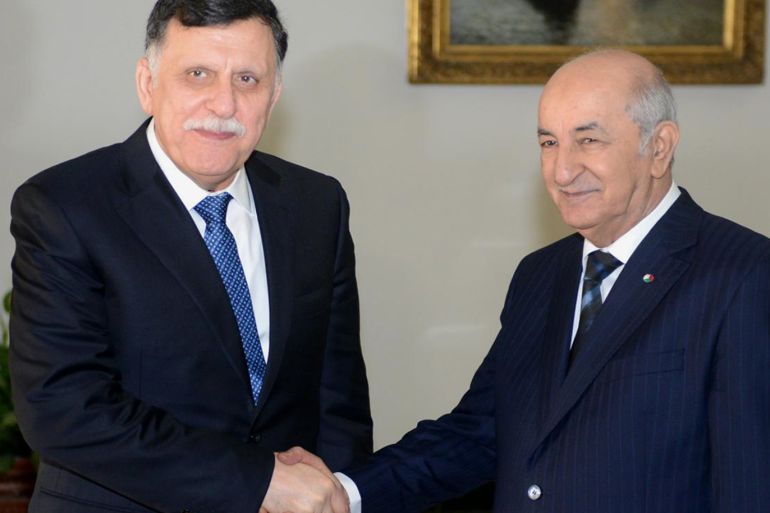 Algeria's President Abdelmajid Tebboune (R) shakes hands with Libya's UN-recognised Prime Minister Fayez al-Sarraj (AFP) copy.jpg
