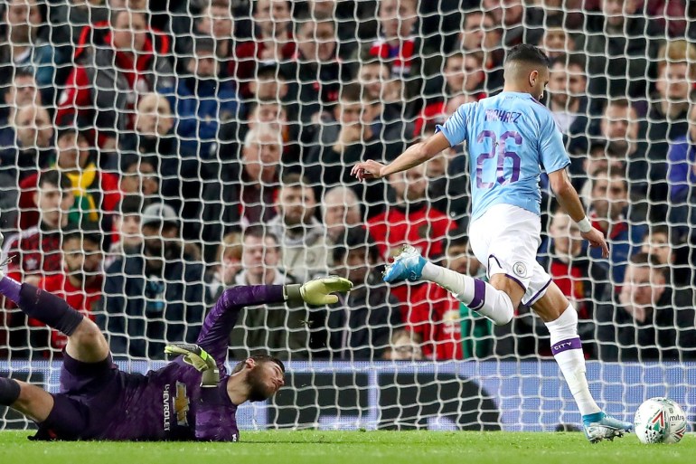 MANCHESTER, ENGLAND - JANUARY 07: Riyad Mahrez of Manchester City takes the ball around David De Gea of Manchester United and scores his sides second goal during the Carabao Cup Semi Final match between Manchester United and Manchester City at Old Trafford on January 07, 2020 in Manchester, England. (Photo by Michael Steele/Getty Images)