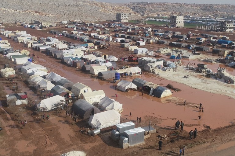 Displaced Syrian civilians struggle to live in Idlib- - IDLIB, SYRIA - DECEMBER 30: A drone photo shows tents amid mud at a refugee camp, which provides living space for Syrians those who escape from the war or displaced by the attacks of Assad Regime and Russia, as refugees leave their home to reach the Turkish border on December 30, 2019 in Idlib, Syria. Refugees have difficulty in finding a living place due to the lack of camp sites, infrastructure and the excessive