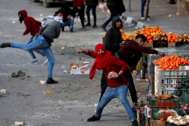 FILE PHOTO: Palestinian demonstrators hurl stones at Israeli forces during a protest against the U.S. President Donald Trump’s Middle East peace plan, in Hebron in the Israeli-occupied West Bank January 30, 2020. REUTERS/Mussa Qawasma/File Photo