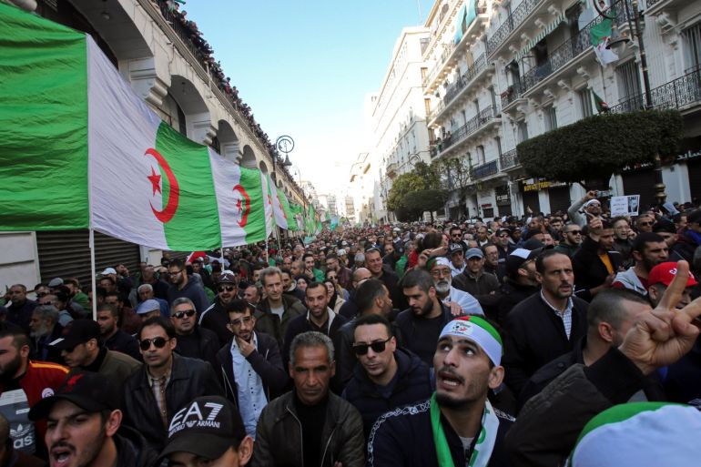 Demonstrators carry a national flag during an anti-government rally in Algiers, Algeria January 3, 2020. REUTERS/Ramzi Boudina