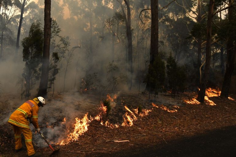 epa08103581 A firefighter works to contain a small bushfire, which closed the Princes Highway, near Ulladulla, Australia, 05 January 2020. According to media reports, at least 1,200 homes in Victoria and New South Wales have been destroyed by fires...