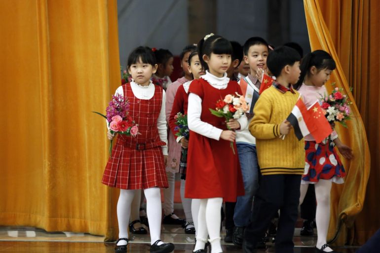 epa04538626 Chinese children carrying flowers and flags arrive for a welcome ceremony for Egyptian President al-Sisi at the Great Hall of the People in Beijing, China, 23 December 2014. It is the Egyptian President's first visit to China. EPA/HOW HWEE YOUNG