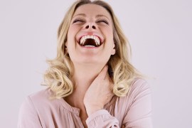 Portrait of laughing blond woman leaning back