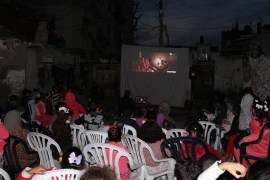 أطفال المخيم النصيرات أثناء مشاهدتهم فيلماً كرتونياً ضمن مبادرة سينما المخيم