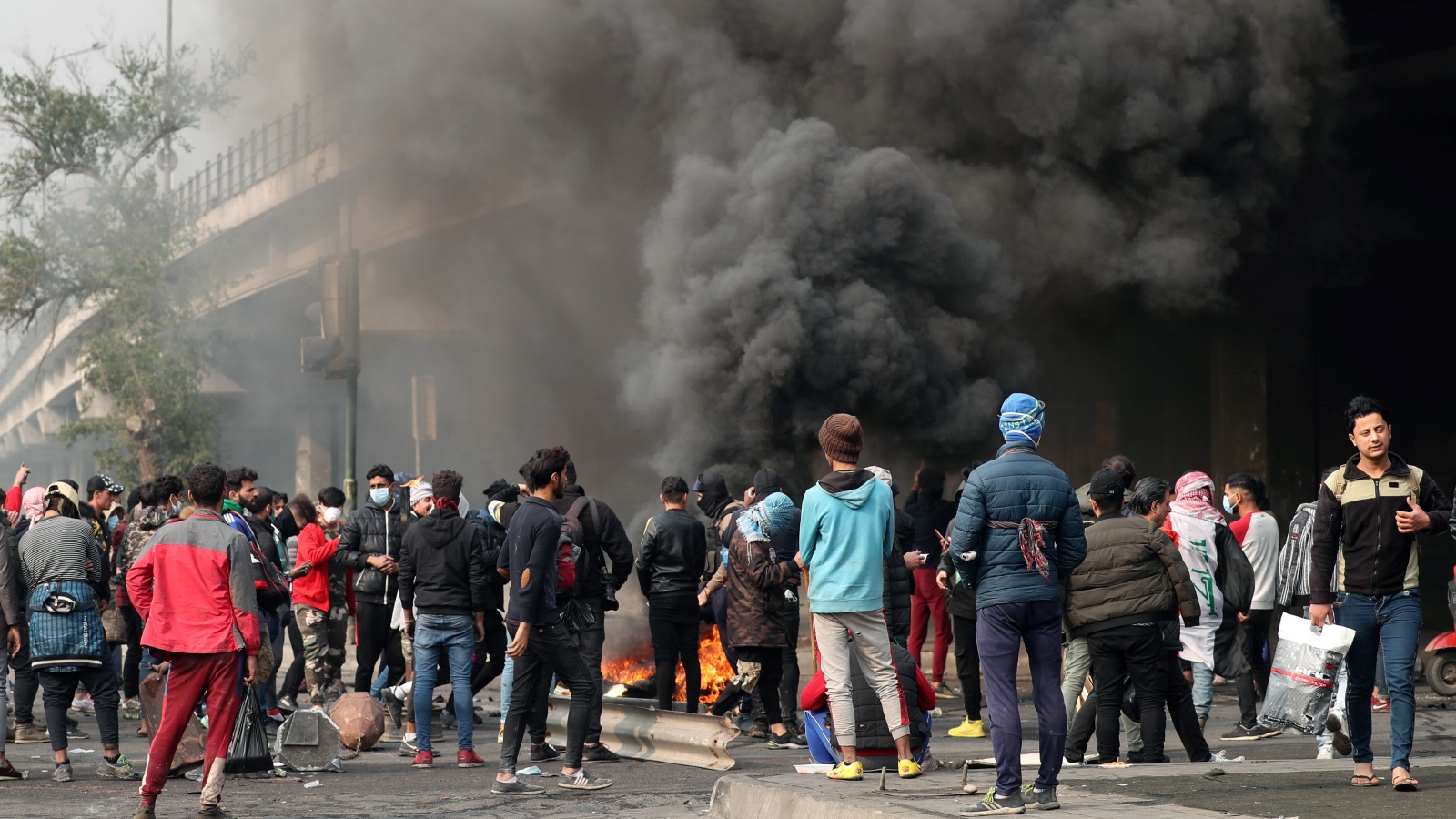 المحتجون خلال إغلاقهم أحد الطرق الرئيسية في بغداد (رويترز)
