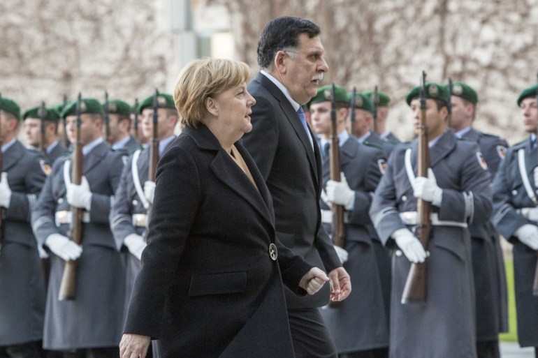 epa06374113 Libyan Prime Minister Fayez al-Sarraj (R) and German Chancellor Angela Merkel (L) walk side by side during a reception with military honors at the Chancellery in Berlin, Germany, 07 December 2017. EPA-EFE/OMER MESSINGER