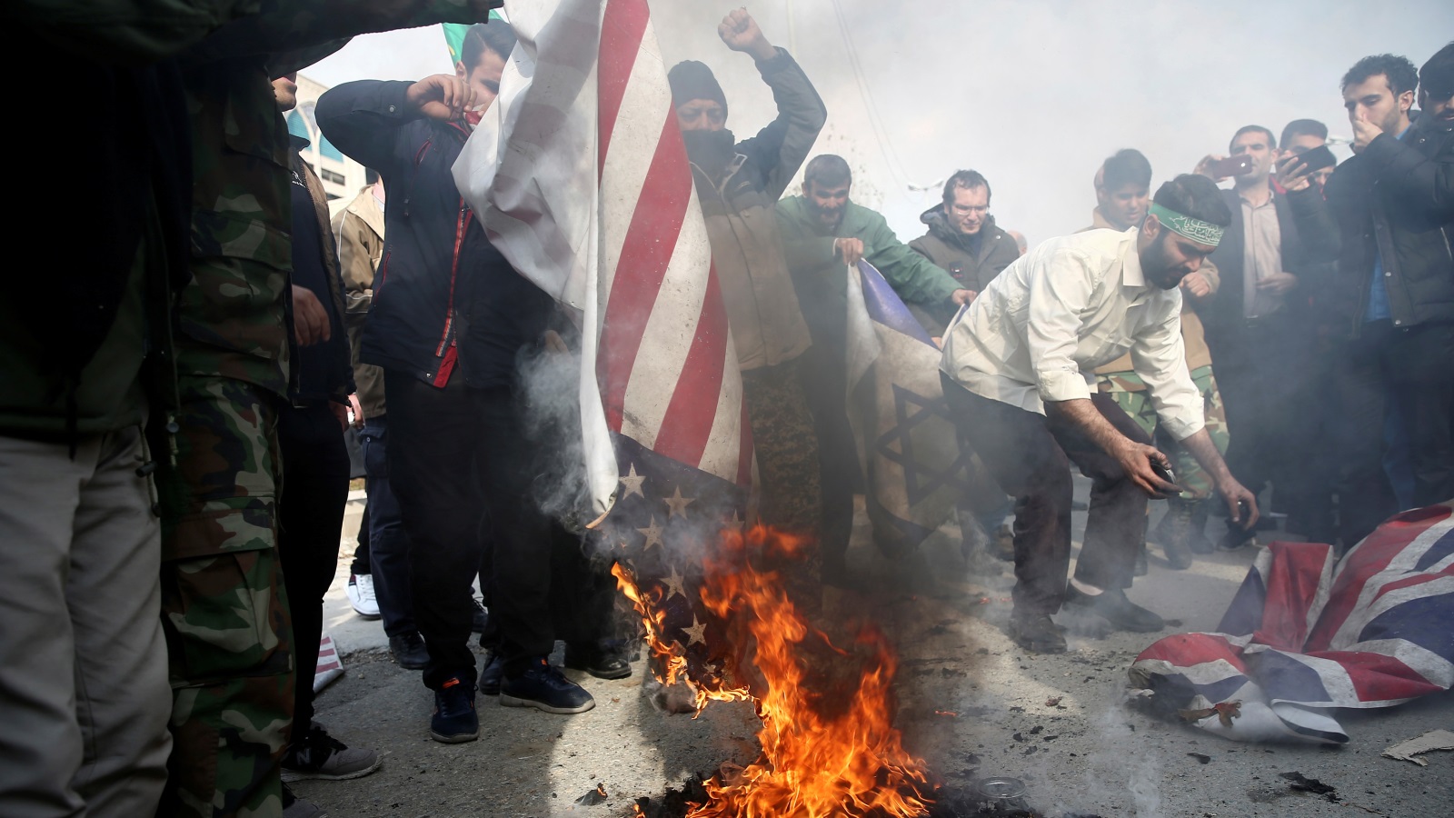 ‪متظاهرون يحرقون أعلاما أميركية وبريطانية في طهران تنديدا باغتيال سليماني‬  (رويترز)
