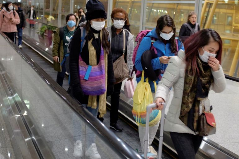 People wear face masks as they arrive at Beijing Capital International Airport in Beijing, January 25, 2020. REUTERS/Thomas Peter