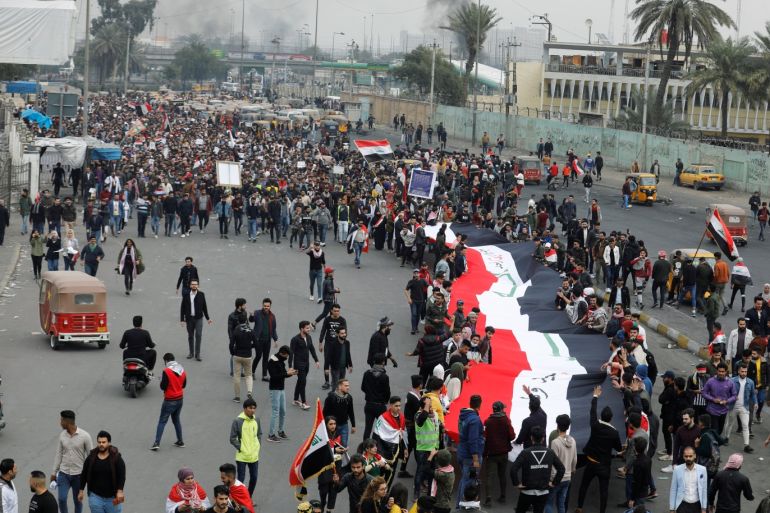 University students hold a huge Iraqi flag during ongoing anti-government protests, in Baghdad, Iraq January 19, 2020. REUTERS/Khalid al-Mousily