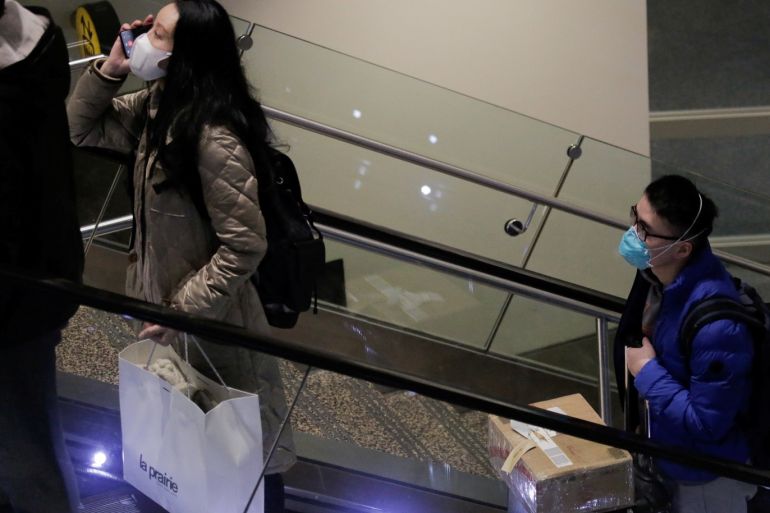 Travellers wearing masks arrive on a direct flight from China, after a spokesman from the U.S. Centers for Disease Control and Prevention (CDC) said a traveller from China had been the first person in the United States to be diagnosed with the Wuhan coronavirus, at Seattle-Tacoma International Airport in SeaTac, Washington, U.S. January 23, 2020. REUTERS/David Ryder
