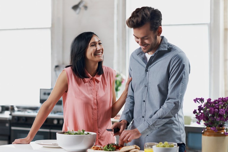 Couple preparing food in the kitchen of their cozy loft apartment
