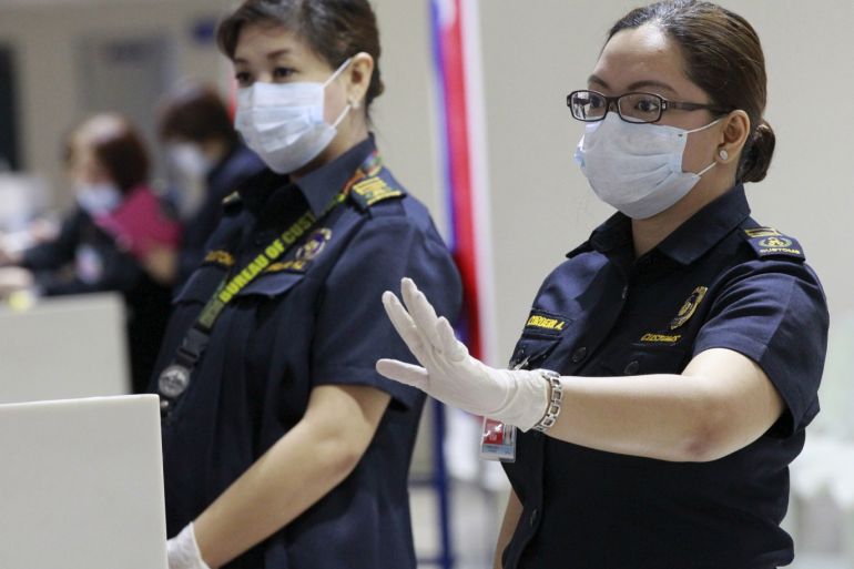 A customs inspector wearing a face mask gestures as she waits for flight passengers arriving from South Korea at the arrival area of Ninoy Aquino International Airport in Manila, June 9, 2015. The World Health Organization said on Tuesday that the outbreak of the Middle East Respiratory Syndrome (MERS) in South Korea was the largest seen outside the Middle East, but it should not be a cause of concern. The South Korea's health ministry said on Tuesday there were eight new MERS cases reported, bringing the total of patients to 95. REUTERS/Romeo Ranoco