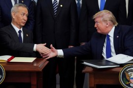 Chinese Vice Premier Liu He and U.S. President Donald Trump shake hands after signing