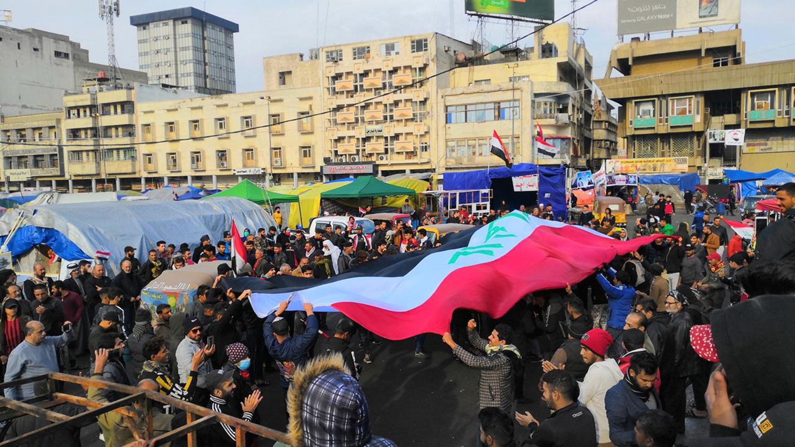 متظاهرو التحرير يرفعون العلم العراقي للتعبير عن عدم انتمائهم لأي طرف أو جهة خارجية (الجزيرة نت)
