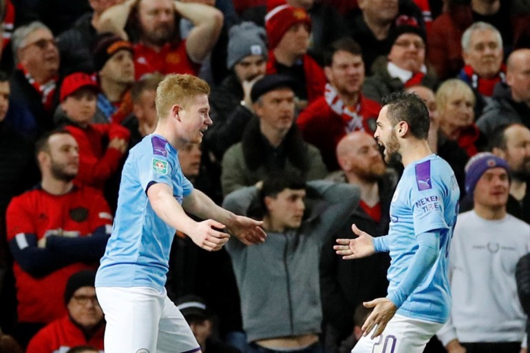 Soccer Football - Carabao Cup - Semi Final First Leg - Manchester United v Manchester City - Old Trafford, Manchester, Britain - January 7, 2020 Manchester City's Kevin De Bruyne celebrates with Bernardo Silva after Manchester United's Andreas Pereira scored an own goal and the third for Manchester City REUTERS/Phil Noble EDITORIAL USE ONLY. No use with unauthorized audio, video, data, fixture lists, club/league logos or