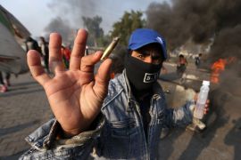 Protest in Iraq- - BAGHDAD, IRAQ - JANUARY 19: A protester shows a spent bullet casing as protesters burn tires to block the road during the anti-government demonstration at al-Tayaran Square in Baghdad, Iraq on January 19, 2020.