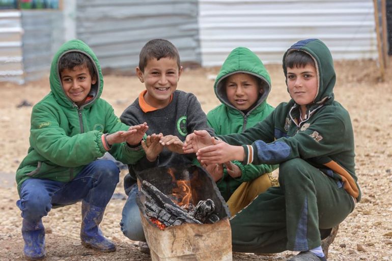 اطفال يشعلون بعض الخشب لتدفئة ايديهم في مخيم الزعتري شمال شرق الاردن . مصدر الصورة العلاقات العامة في مفوضية اللاجئين.