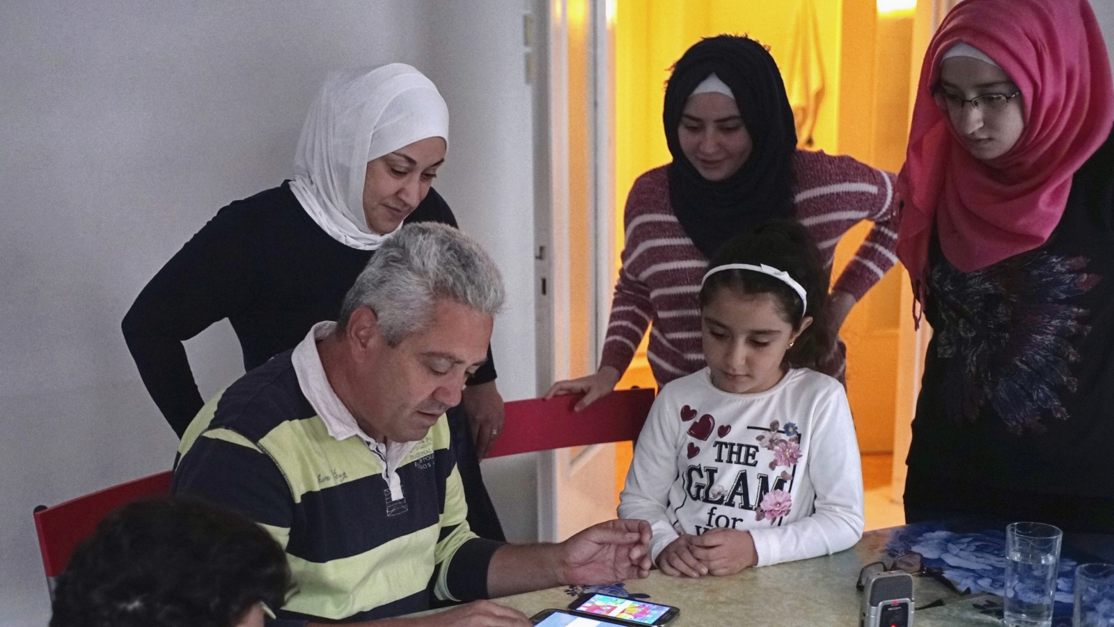 ‪لاجئ سوري وزوجته وأطفالهما يقيمون في اليونان ويحاولون الاتصال عبر الإنترنت بذويهم في أرض الوطن‬ (غيتي)
