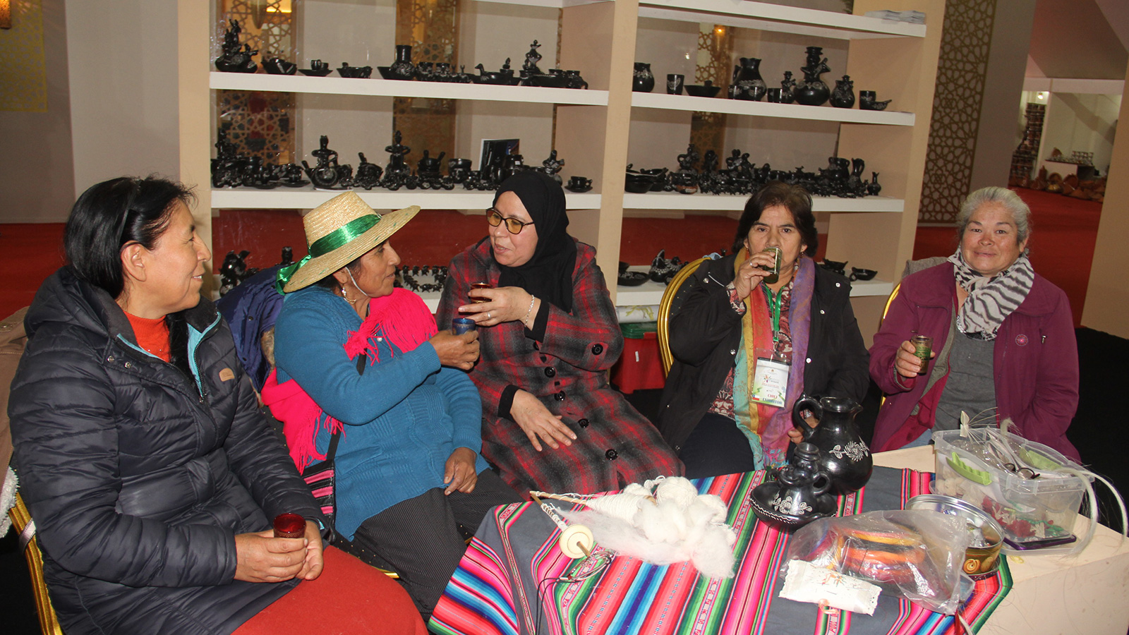 ‪نساجات من المغرب وتشيلي يستمتعن بشرب الشاي المغربي بعد نهاية الورشة ويأملن بلقاء جديد‬ (الجزيرة)