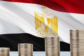 Egypt flag waving in the background with rows of coins for finance and business concept. Saving money.