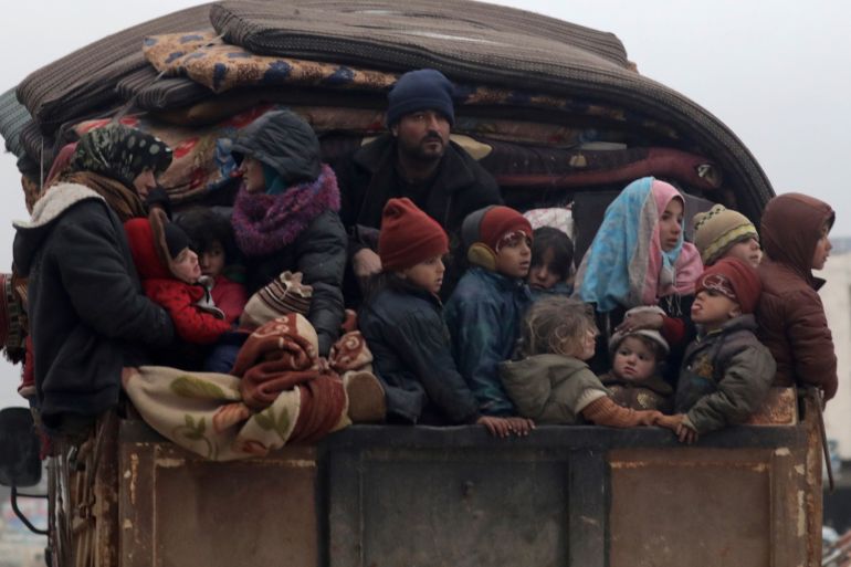 Internally displaced Syrians from western Aleppo countryside, ride on the back of a truck with belongings in Hazano near Idlib, Syria, February 11, 2020. REUTERS/Khalil Ashawi