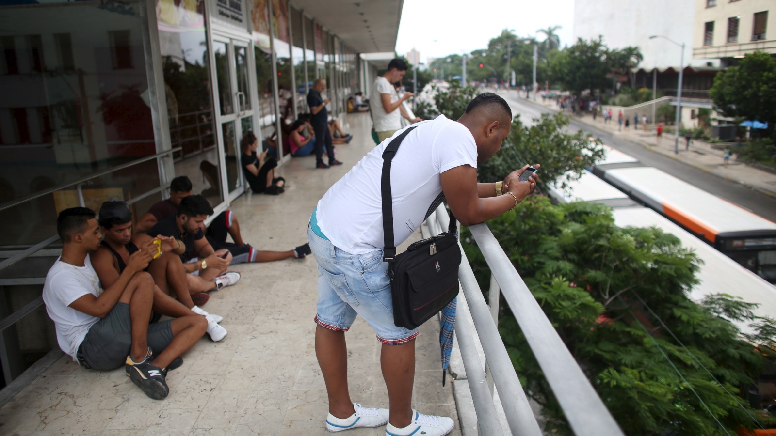 ‪شباب في العاصمة الكوبية هافانا يطالعون هواتفهم في مكان مغطى بشبكة الواي فاي‬ (رويترز)