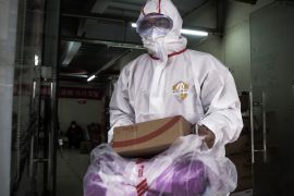 WUHAN, CHINA - FEBRUARY 01: (CHINA OUT) An expressman wears a protective mask and suit as he carries packages on February 1, 2020 in Wuhan, Hubei province, China. The number of those who have died from the Wuhan coronavirus, known as 2019-nCoV, in China climbed to 259 and cases have been reported in other countries including the United States, Canada, Australia, Japan, South Korea, India, the United Kingdom, Germany, France, and several others. (Photo by Stringer/Getty Images)