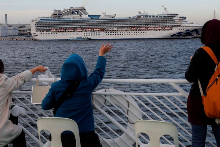 Tourists on a sightseeing cruise ship wave to passengers of the cruise ship Diamond Princess, which is anchored at Daikoku Pier Cruise Terminal in Yokohama, south of Tokyo, Japan February 12, 2020. REUTERS/Kim Kyung-hoon TPX IMAGES OF THE DAY