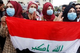 Iraqi women demonstrators wear protective face masks, following the outbreak of the new coronavirus, as they carry Iraqi flag during ongoing anti-government protests in Baghdad, Iraq February 25, 2020. REUTERS/Wissm al-Okili