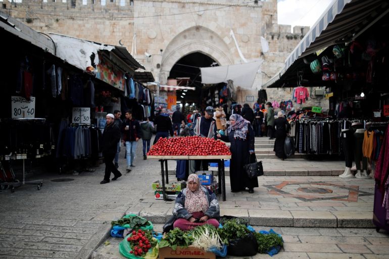 People walk past vendors at a market in Jerusalem's Old City January 28, 2020. REUTERS/Ammar Awad