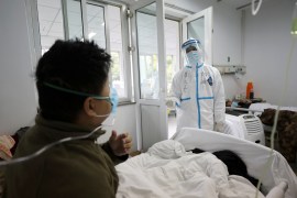 A medical worker in protective suit interacts with a patient inside an isolated ward at Jinyintan Hospital in Wuhan, the epicentre of the novel coronavirus outbreak, in Hubei province, China February 13, 2020. Picture taken February 13, 2020. China Daily via REUTERS ATTENTION EDITORS - THIS IMAGE WAS PROVIDED BY A THIRD PARTY. CHINA OUT.