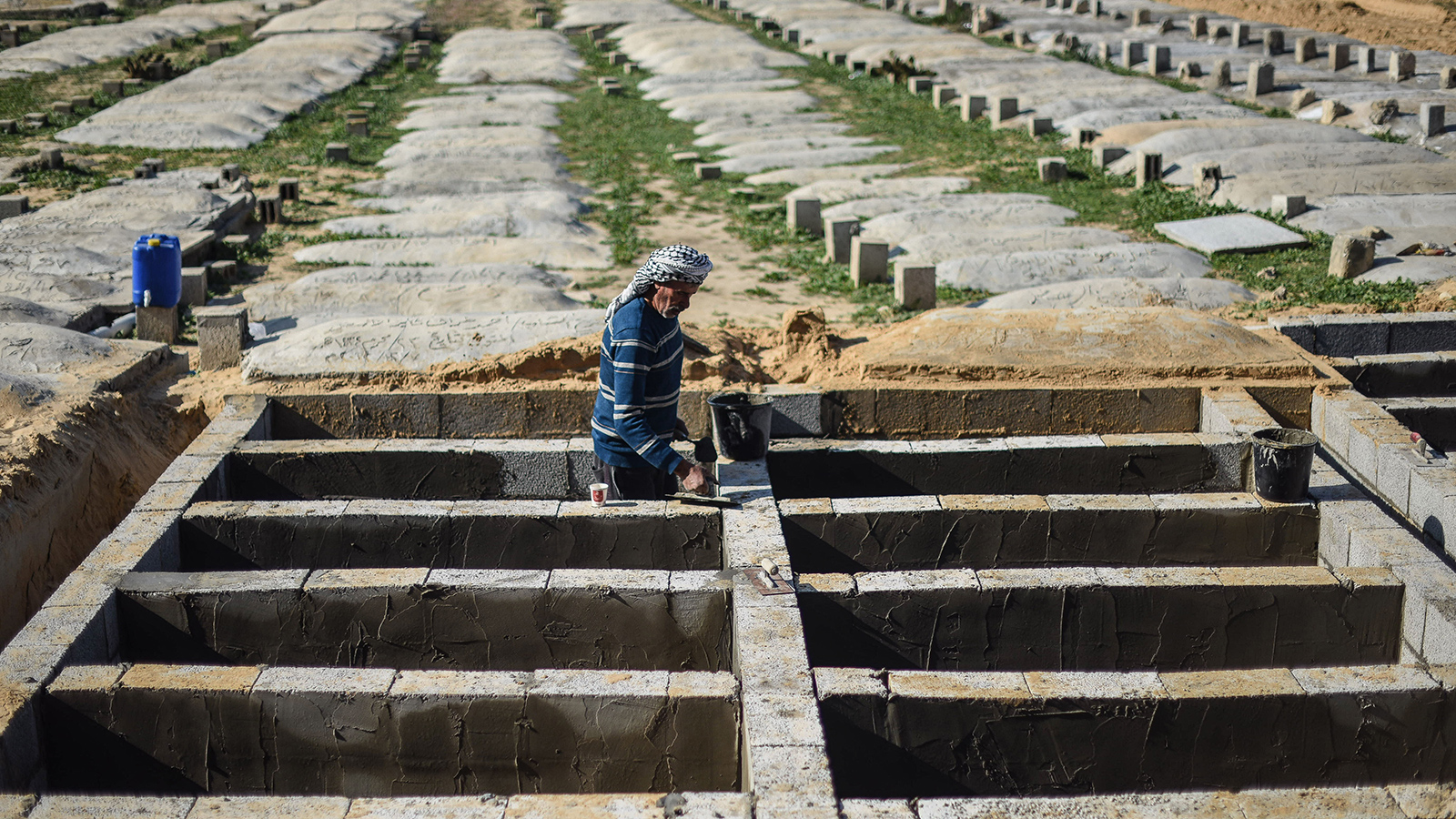 ‪حفر عدد من القبور لفقراء عائلة الأسطل في غزة‬ (الجزيرة)