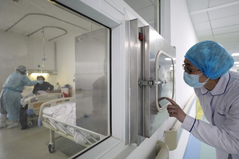 A medical worker calls his colleague inside an isolated ward at Jinyintan Hospital in Wuhan, the epicentre of the novel coronavirus outbreak, in Hubei province, China February 13, 2020. Picture taken February 13, 2020. China Daily via REUTERS ATTENTION EDITORS - THIS IMAGE WAS PROVIDED BY A THIRD PARTY. CHINA OUT.