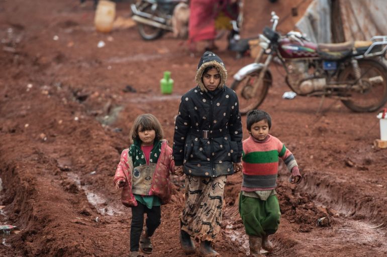 IDLIB, SYRIA - FEBRUARY 21: Displaced Syrian children walk on mud at Marabune camp on February 21, 2020 in Idlib, Syria. Turkey’s President Recep Tayyip Erdogan in a speech Tuesday threatened, “imminent operations in Syria’s Idlib if Damascus fails to withdraw behind Turkish positions” The threat comes after Syria’s government and its ally Russia rejected demands to pull back to ceasefire lines agreed upon in the 2018 Sochi accord. More than 900,000 civilians have been displaced by fighting in or around Idlib since December 1. Idlib is the last rebel stronghold of fighters trying to overthrow Syrian President Bashar al-Assad and in the past years has become the last safe haven for civilians displaced by fighting in other areas of Syria, its population has doubled to close to three million people, many of whom are now fleeing the government offensive towards overcrowded camps close to the Turkish border amid freezing conditions, creating a humanitarian disaster. (Photo by Burak Kara/Getty Images)