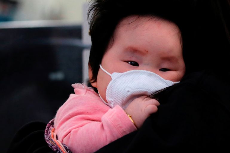 A child wears a mask to prevent an outbreak of a new coronavirus at the Hong Kong West Kowloon High Speed Train Station, in Hong Kong, China January 23, 2020. REUTERS/Tyrone Siu