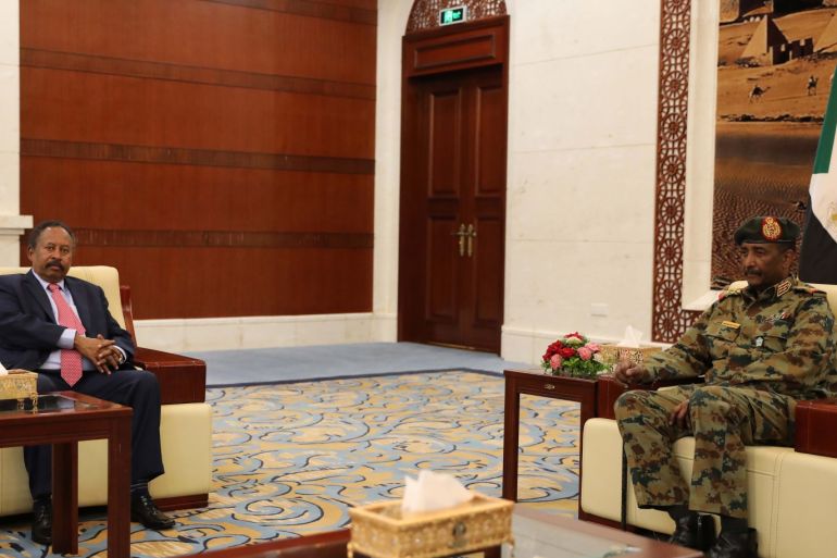 epa07784908 Sudan's new Prime Minister Abdalla Hamdok (L) meets with General Abdel Fattah Abdelrahman Burhan (R) after being sworn in during a ceremony at the presidential palace in Khartoum, Sudan, 21 August 2019. The Sudanese opposition and military council signed on 17 August a power sharing agreement. The agreement sets up a sovereign council made of five generals and six civilians, to rule the country until general elections. Protests had erupted in Sudan in December 2018, culminating in a long sit-in outside the army headquarters which ended with more than one hundred people being killed and others injured. Sudanese President Omar Hassan al-Bashir stepped down on 11 April 2019. EPA-EFE/MARWAN ALI