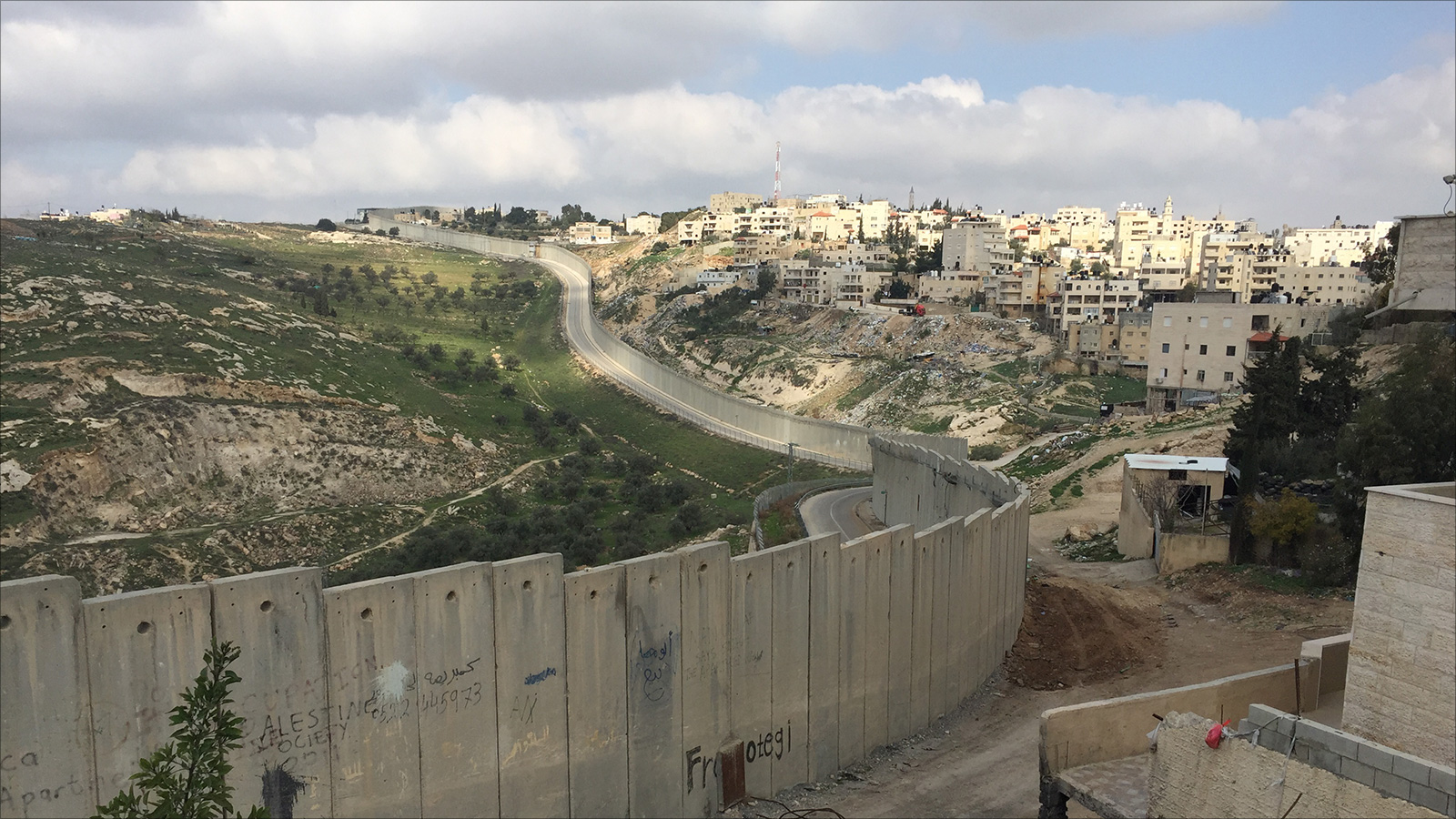 ‪(الجزيرة)‬ جانب من جدار الفصل  الذي يمر من وسط الأحياء والشوارع في بلدة أبو ديس والذي فصلها عن مدينة القدس 