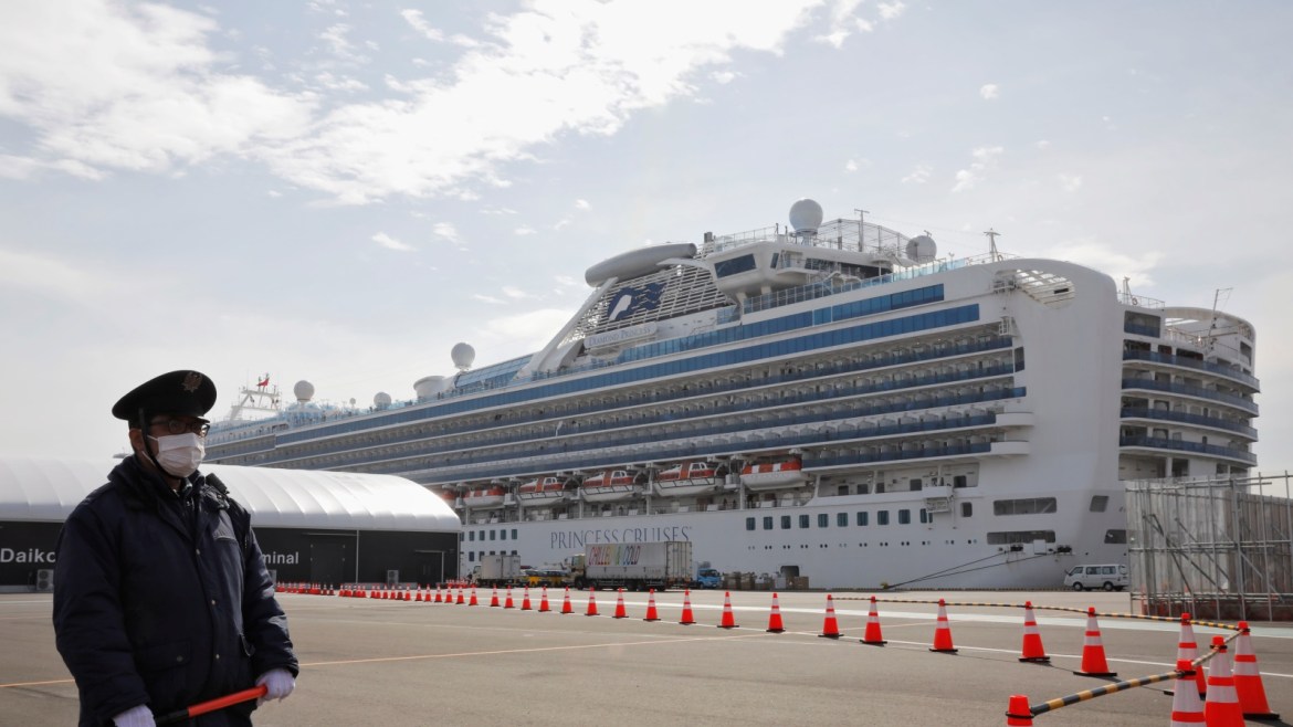 A man wearing a mask stands guard at the port next to the cruise ship Diamond Princess at Daikoku Pier Cruise Terminal in Yokohama, south of Tokyo, Japan February 12, 2020. REUTERS/Kim Kyung-hoon