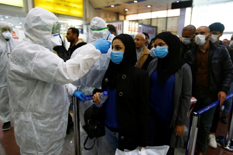 Iraqi medical staff check passengers' temperature, amid the new coronavirus outbreak, upon their arrival at Najaf airport, Iraq February 20, 2020. REUTERS/Alaa al-Marjani.