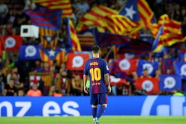 Barcelona's Lionel Messi stands on the pitch in the Camp Nou stadium as fans wave pro-independence flags and banners during a Spanish La Liga match against Eibar in Barcelona, Spain, September 19, 2017. Picture taken September 19, 2017. REUTERS/Albert Gea