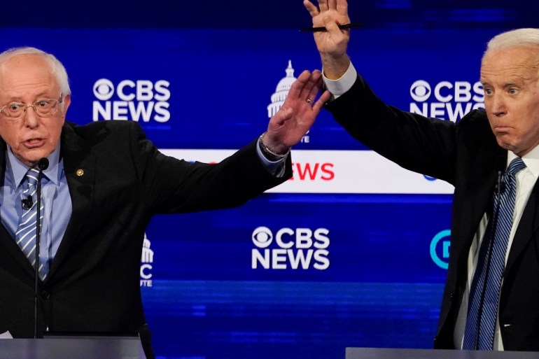 Democratic 2020 U.S. presidential candidates Senator Bernie Sanders and former Vice President Joe Biden brush hands as they have an exchange in the tenth Democratic 2020 presidential debate at the Gaillard Center in Charleston, South Carolina, U.S. February 25, 2020. REUTERS/Jonathan Ernst