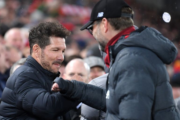 LIVERPOOL, ENGLAND - MARCH 11: Diego Simeone, Manager of Atletico Madrid and Jurgen Klopp, Manager of Liverpool bump elbows prior to the UEFA Champions League round of 16 second leg match between Liverpool FC and Atletico Madrid at Anfield on March 11, 2020 in Liverpool, United Kingdom. (Photo by Laurence Griffiths/Getty Images)