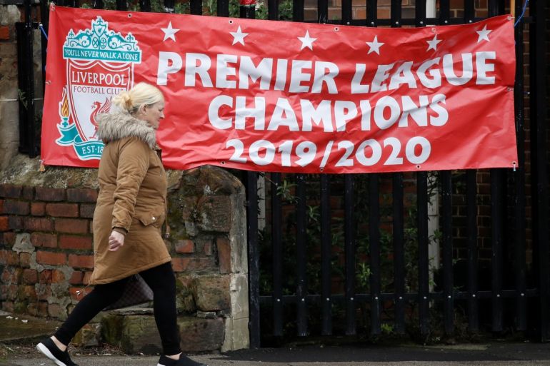 A woman walks past a banner stating